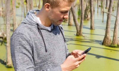 a guy betting on sports on his mobile phone in the swamps of MS