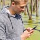 a guy betting on sports on his mobile phone in the swamps of MS
