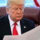 President Trump reading the Big Beautiful Bill in the Oval Office