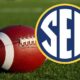 an SEC logo over a football resting on a field
