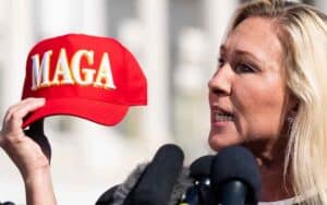 MGT holding a MAGA hat