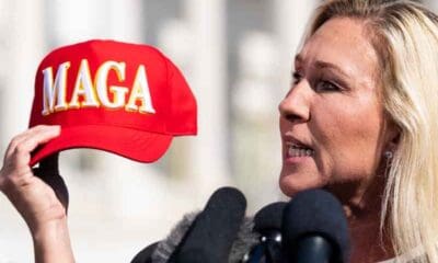 MGT holding a MAGA hat