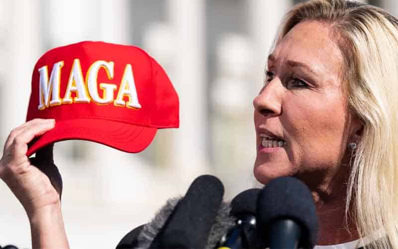 MGT holding a MAGA hat