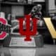 Indiana, Vanderbilt, and Ohio State logos over a black and white image of the Heisman Trophy