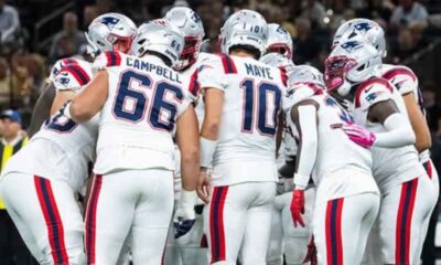 A New England Patriots huddle led by Drake Maye