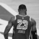 a black and white image of LeBron James walking onto an NBA court