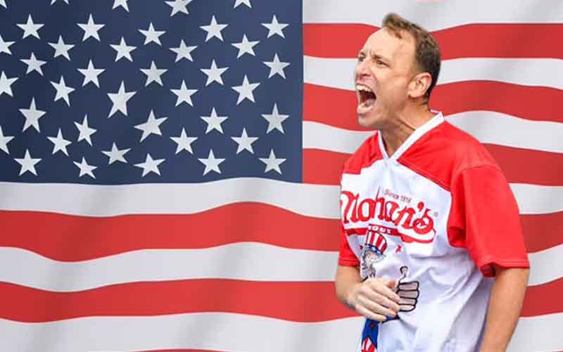 Joey Chestnut celebrating in front of a US flag