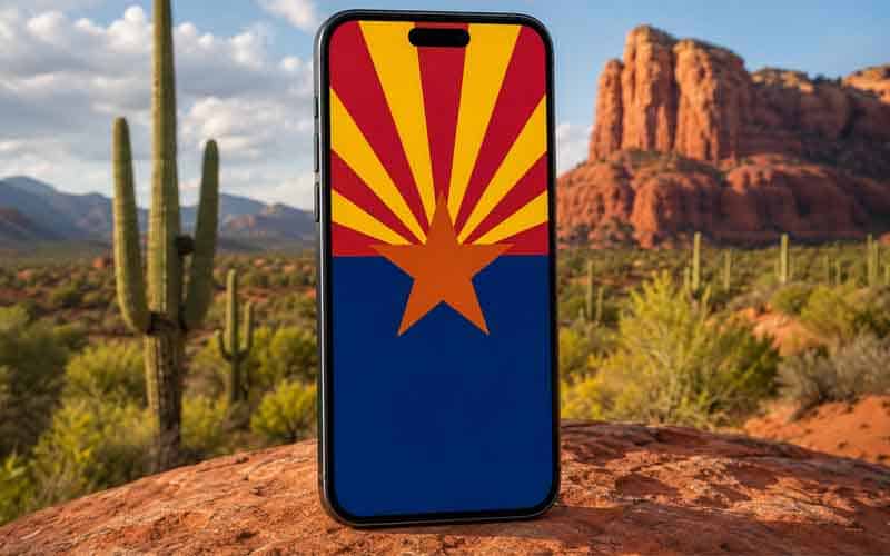 an image of a smartphone with an Arizona flag on the display, positioned in front of the AZ desert