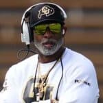 Deion Sanders with his arms folded on the Colorado sidelines