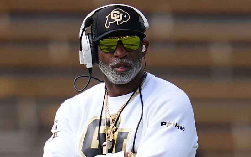 Deion Sanders with his arms folded on the Colorado sidelines